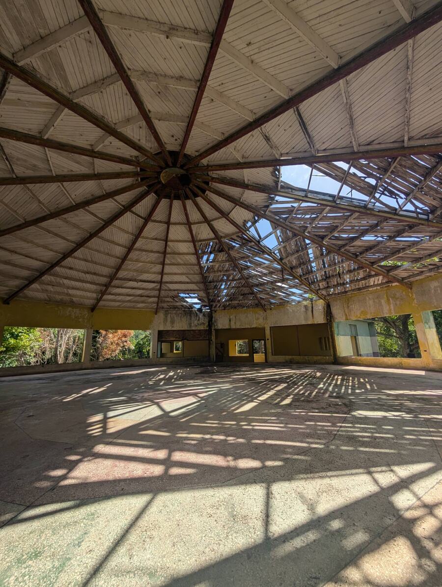 Inside the old octagonal church, with radiating roof beams and a partly open roof